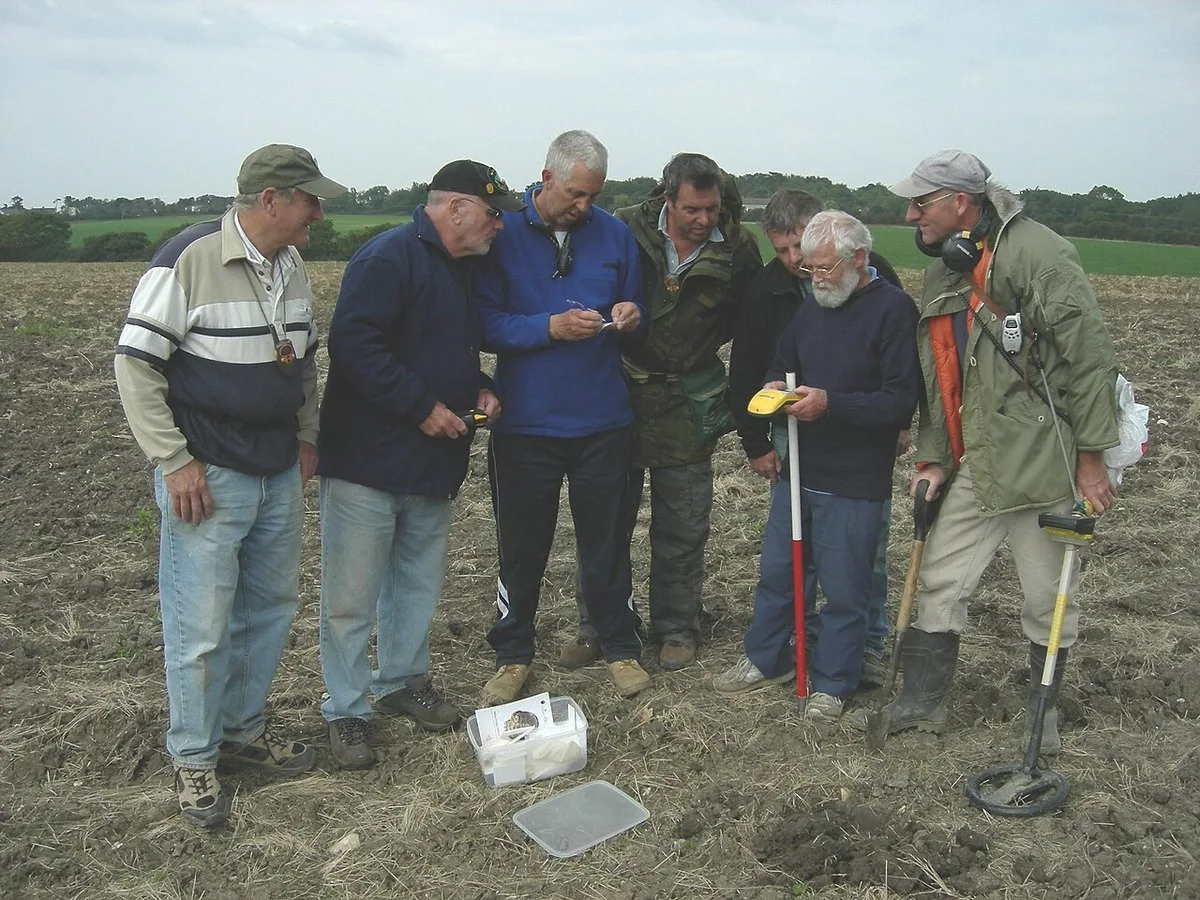 Members of a metal detecting club searching a field on the Isle of Wight