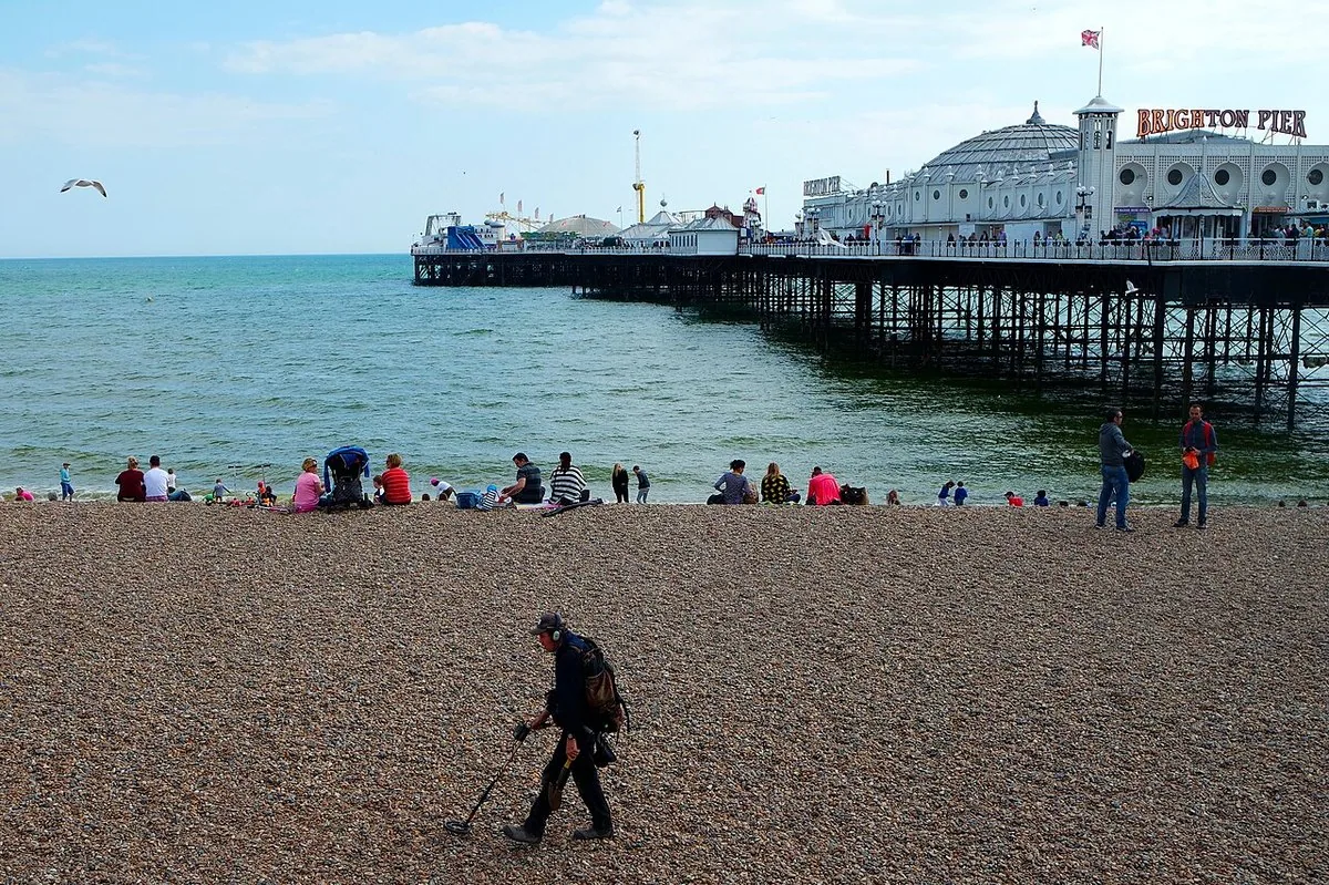 Metal detecting on Brighton Beach near the pier