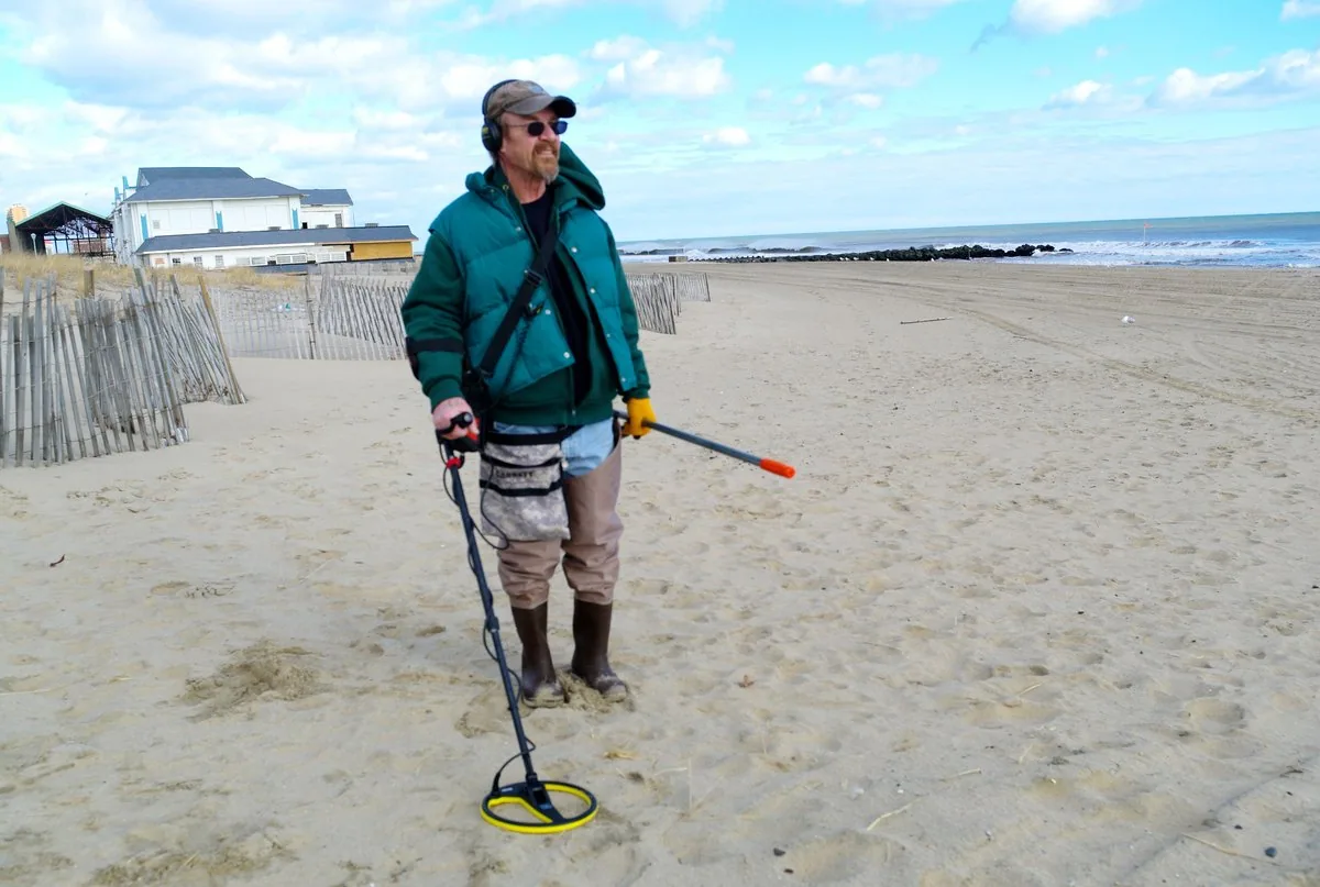 Person using a metal detector on a beach
