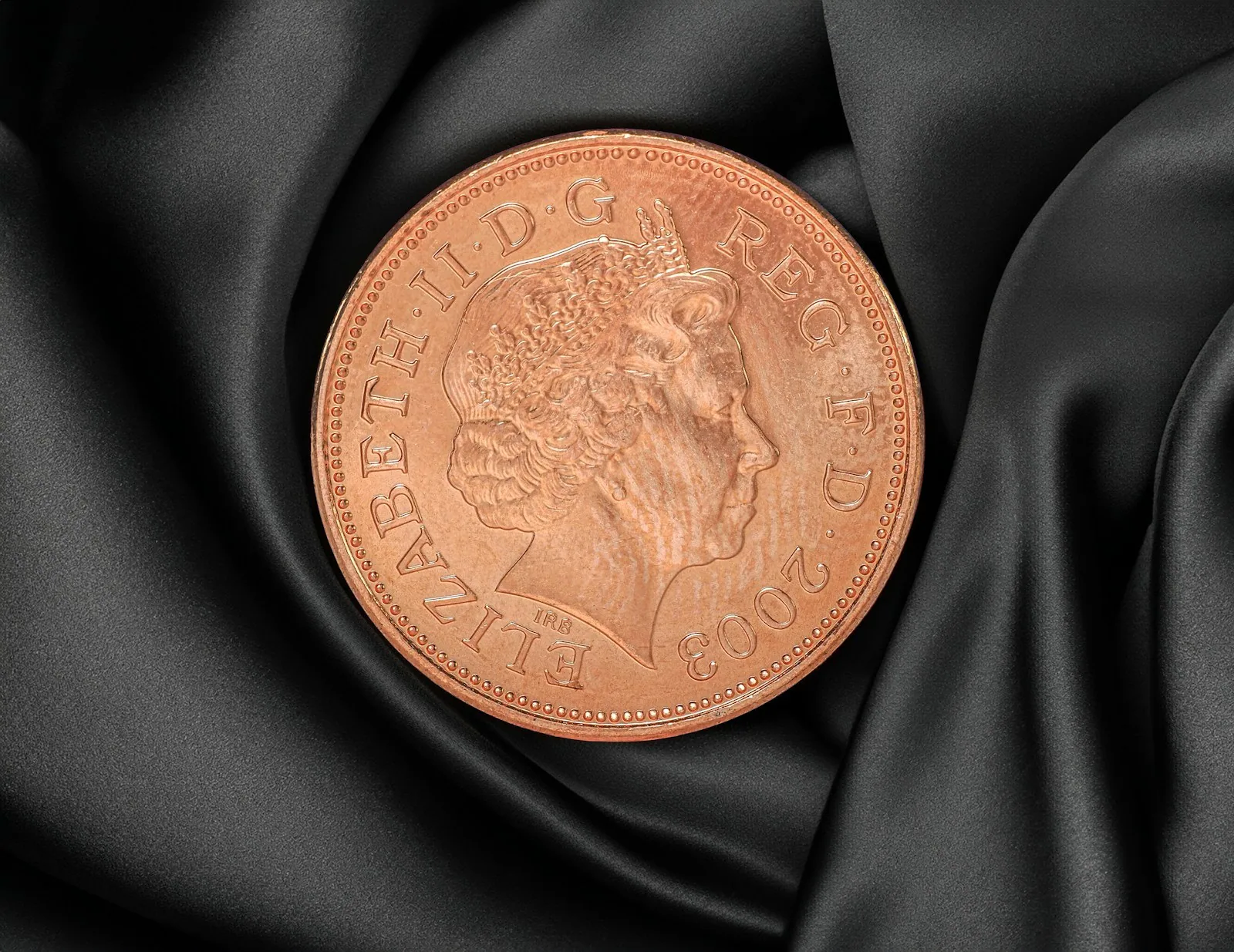 British one pence coin on a black background