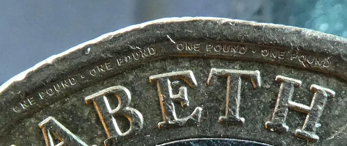 Close-up of the edge lettering on a UK one pound coin