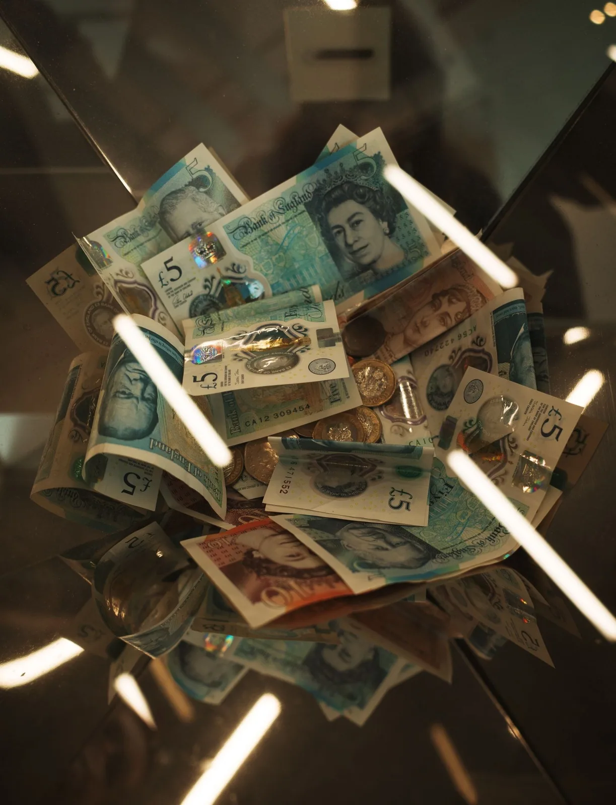 British currency in a glass box Pile of British pound currency inside a glass box